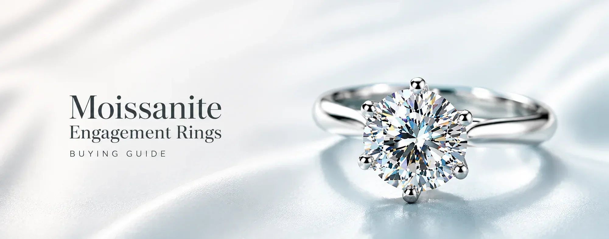 Hero banner for a Moissanite Engagement Rings Buying Guide featuring a round brilliant moissanite solitaire engagement ring in a six-prong white gold setting on a soft blue background with elegant typography.