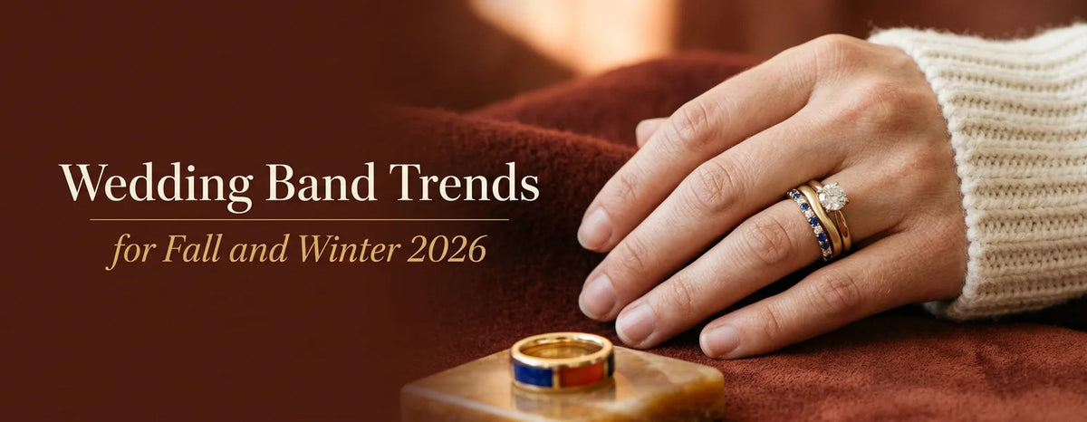 A hand in a cream knit sleeve wears a diamond ring with stacked gold and sapphire bands on a rust background, beside the title "Wedding Band Trends for Fall and Winter 2026".