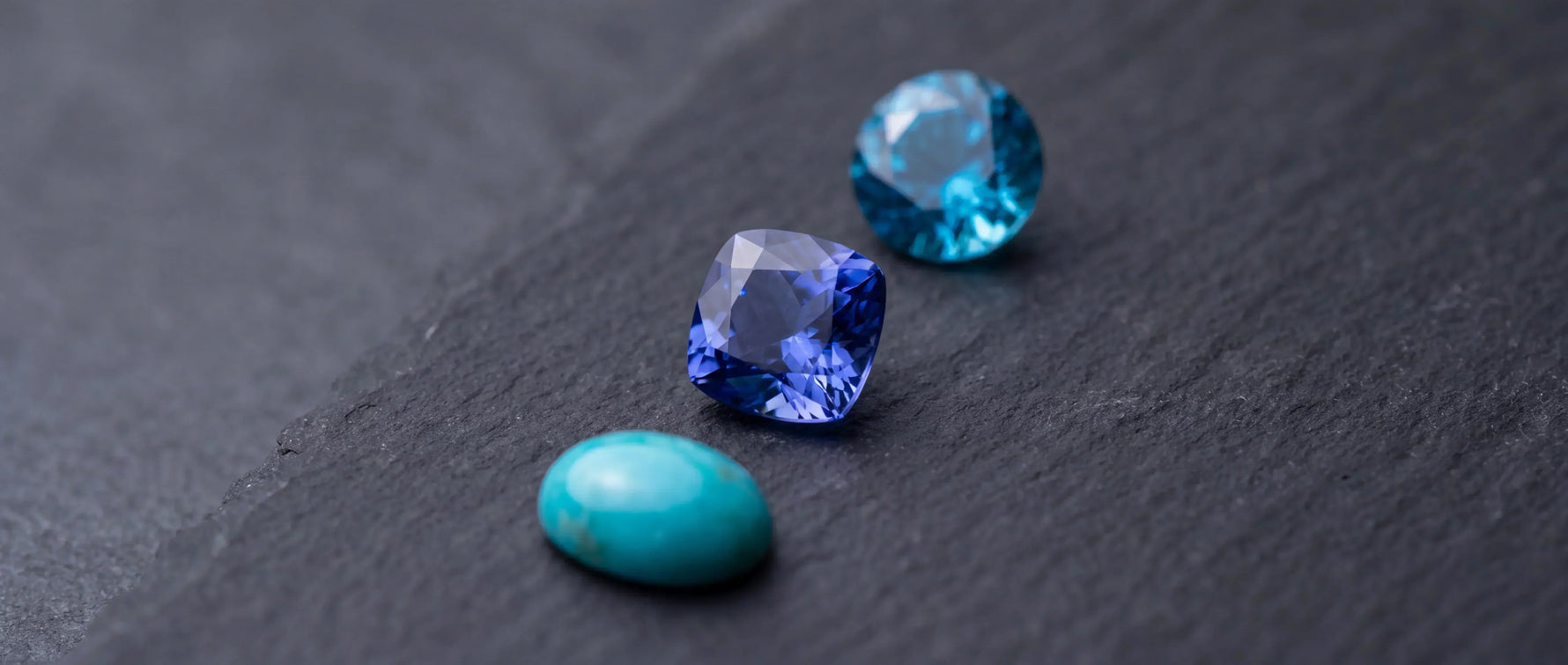 Turquoise, tanzanite, and zircon gemstones displayed together, showing the three December birthstones