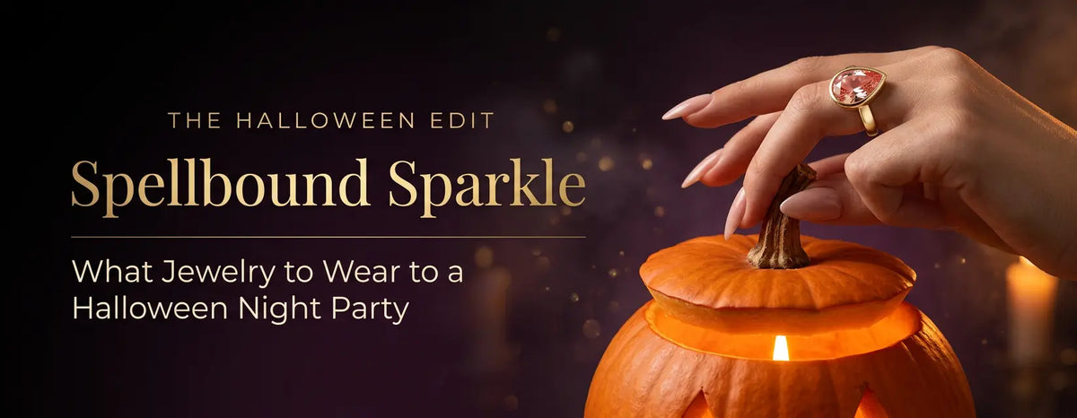 Hand holding a pumpkin stem wearing a gold pear-shaped pink gemstone ring, Halloween night party jewelry ideas