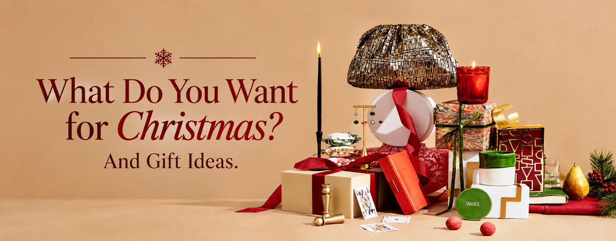 A festive Christmas gift display featuring elegantly wrapped presents, red ribbons, candles, ornaments, and decorative accessories 