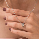 Model wearing a classic yellow gold radiant Diamond necklace featuring an elongated bezel-set solitaire pendant.