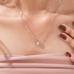 Model wearing a classic yellow gold radiant Diamond necklace featuring an elongated bezel-set solitaire pendant.