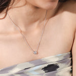 Model wearing an elegant Round Diamond necklace with a bezel-set solitaire diamond on a fine white gold chain.
