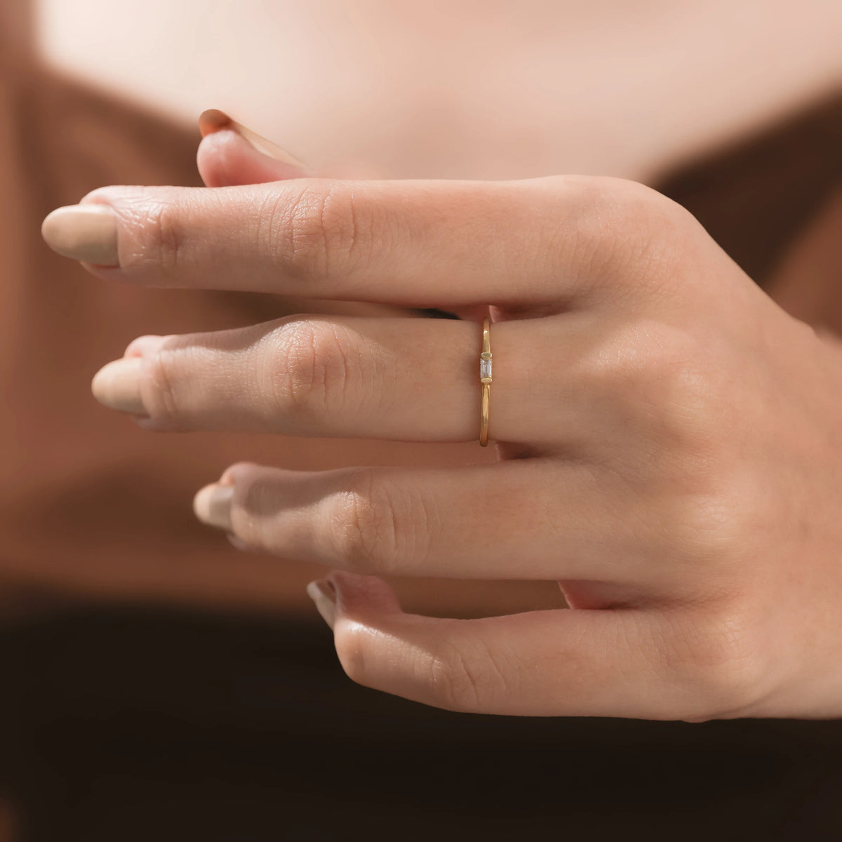 An elegant 14k yellow gold promise ring showcasing a tiny rectangular diamond stone set flat on an ultra thin wire band.