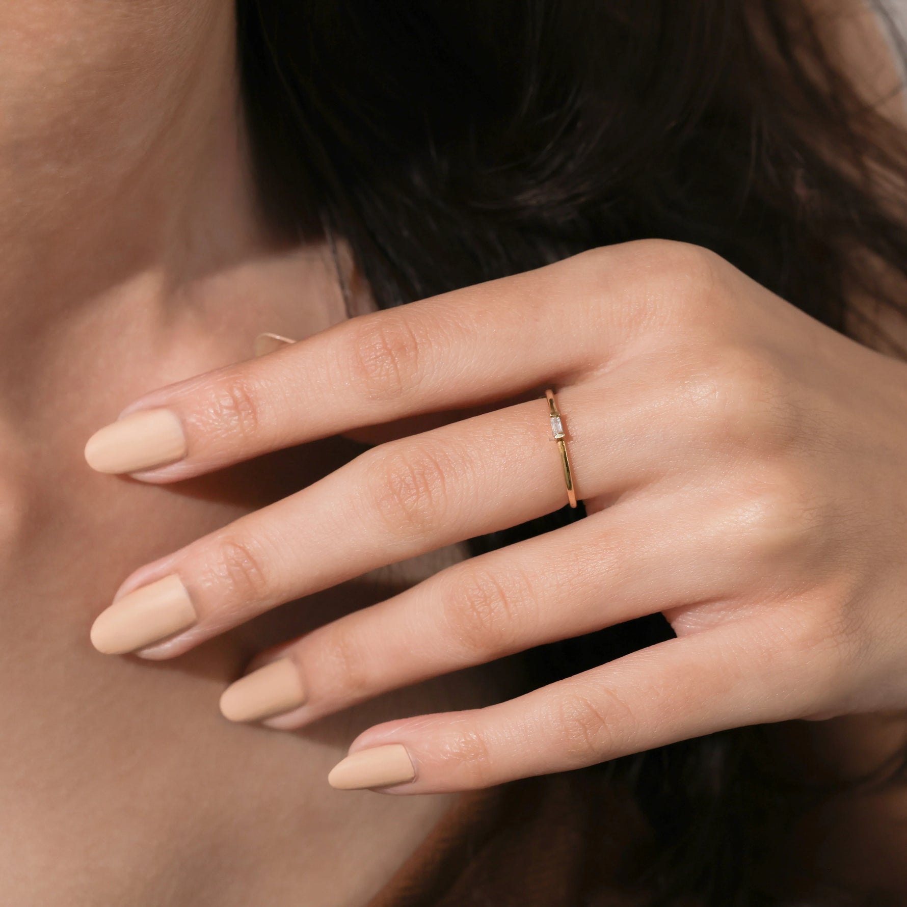 A dainty yellow gold fine jewelry ring with a subtle east west baguette gemstone, styled effortlessly for a modern daily look.