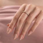Close-up of a yellow gold mosaic ring with baguette and round diamonds on a woman's hand. Geometric wedding band jewelry styling. 