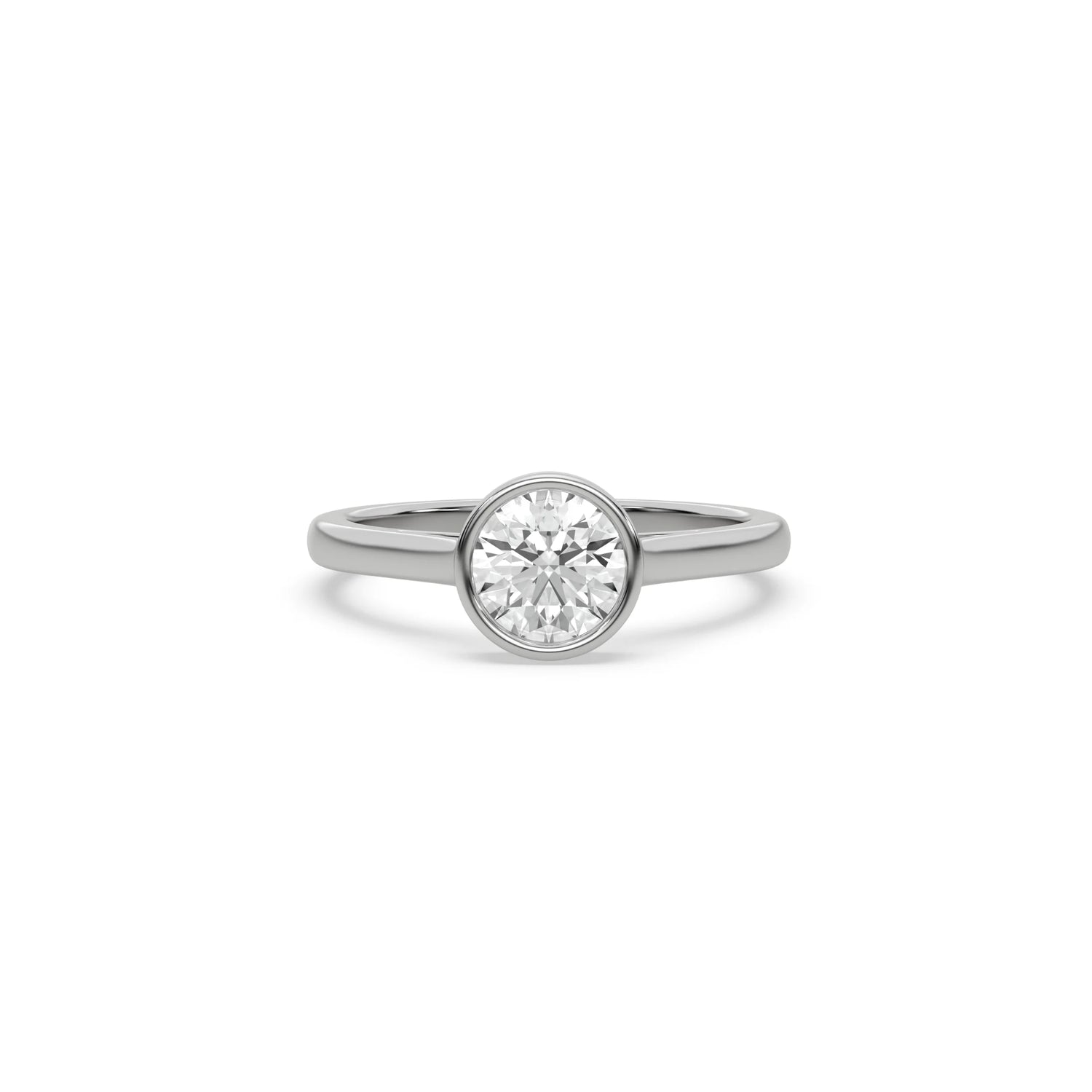 Modern round-cut diamond engagement ring in a white gold bezel setting, featuring a polished slim solitaire band isolated on a clean white background.
