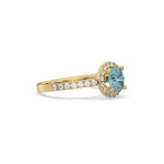 This yellow gold ring displayed in side view is made with a round solitaire diamond set in four-prong setting