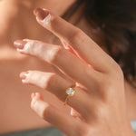 Model lifestyle photo of a 14k gold cushion diamond engagement ring with a secure low-profile bezel setting, showcasing elegant fine jewelry on a hand.