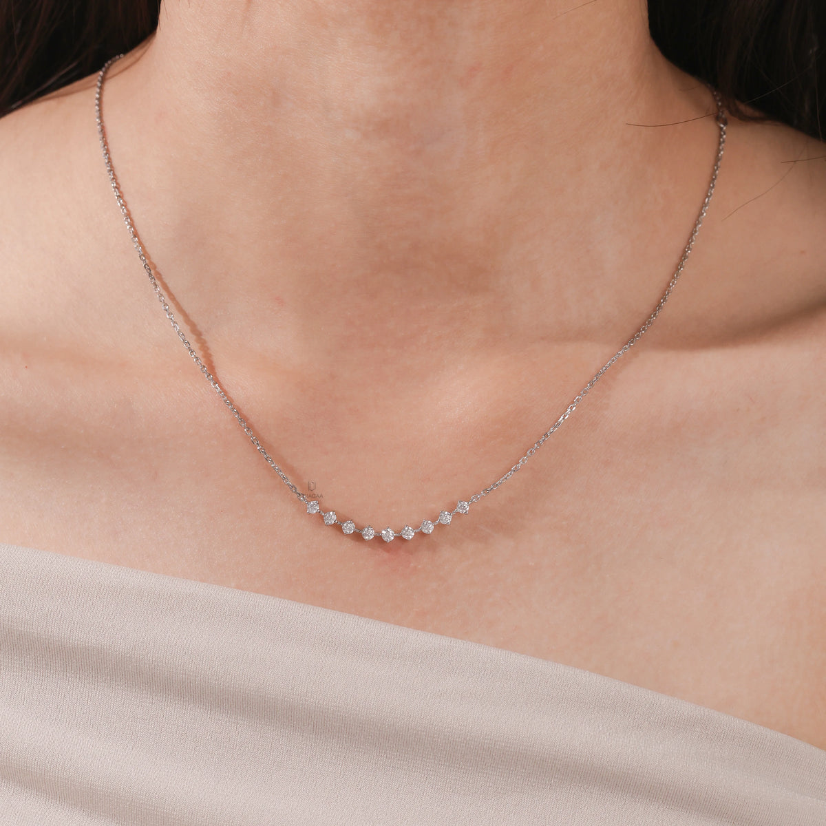 Elegant curved bar round diamond necklace with prong-set stones, shown on model and available in white gold.