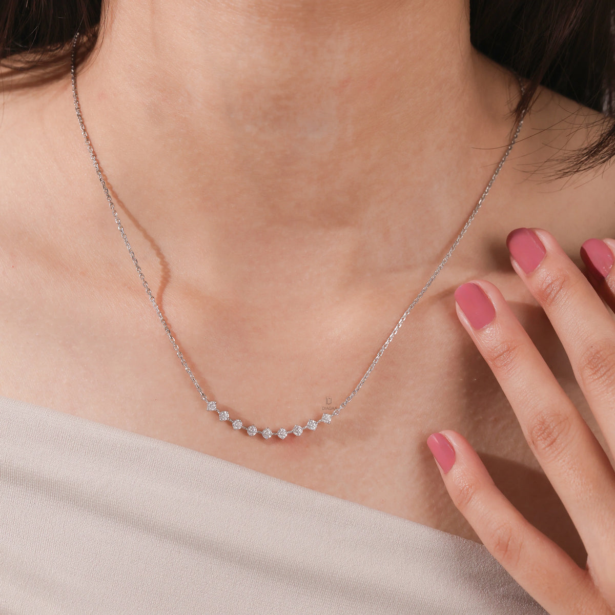 Elegant curved bar round diamond necklace with prong-set stones, shown on model and available in white gold.