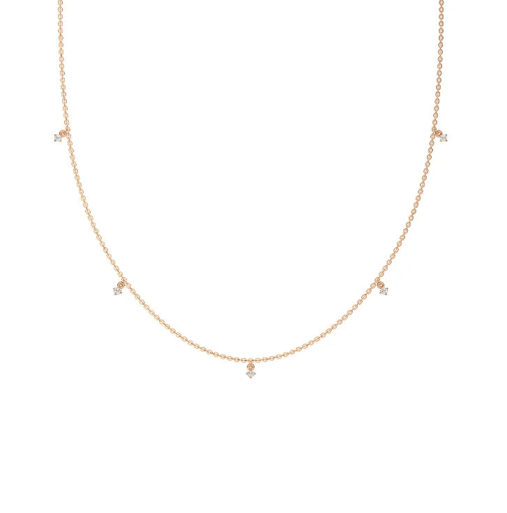 Modern yellow gold round diamond dangling necklace designed with three brilliant prong-set round stones on a fine link chain with a white background.
