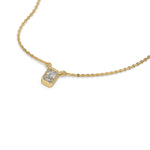 High-angle view of a bezel-set radiant Diamond necklace featuring an elongated solitaire stone in yellow gold.