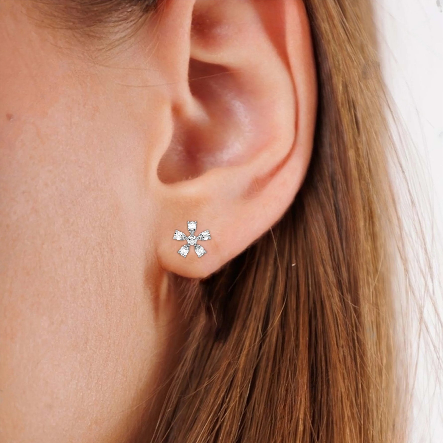 This white gold Floral Diamond Earrings made using pear diamonds for the petals and a round brilliant-cut diamond in the center creating a beautiful flower design, securely set in prong setting