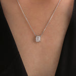 Model wearing a classic yellow gold Emerald Diamond necklace featuring a step-cut bezel-set solitaire pendant.