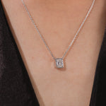Model wearing a classic yellow gold Emerald Diamond necklace featuring a step-cut bezel-set solitaire pendant.
