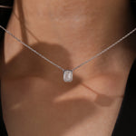 Model wearing a classic yellow gold Emerald Diamond necklace featuring a step-cut bezel-set solitaire pendant.