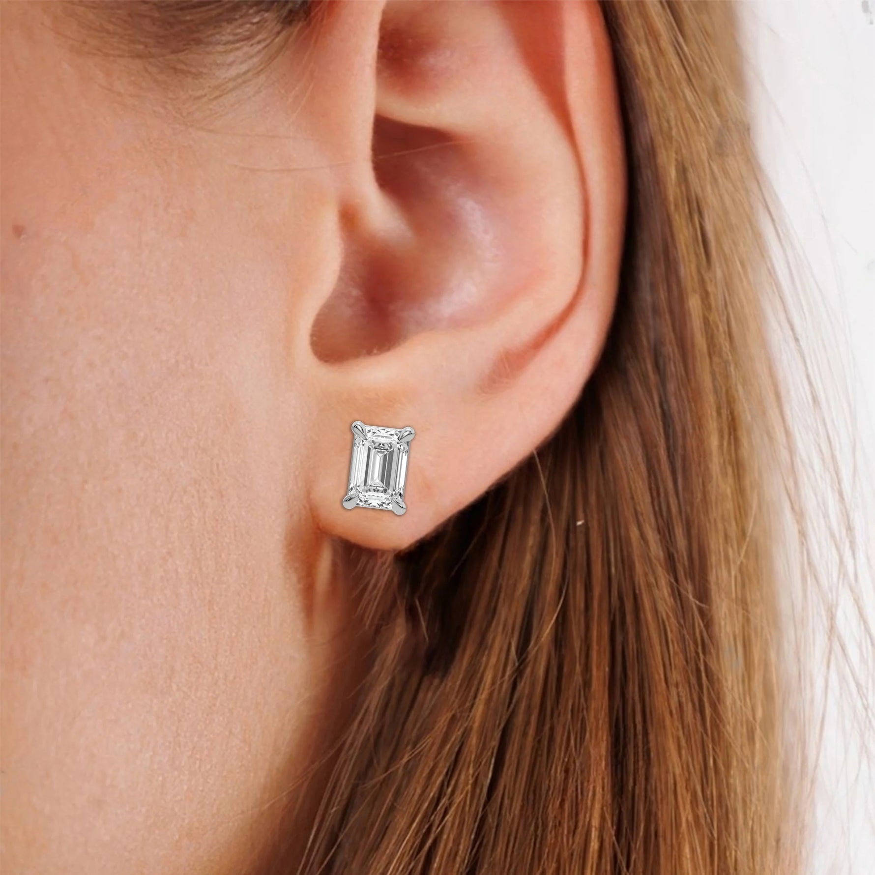 This white gold Classic Emerald Diamond Earrings made with an emerald-cut diamonds set in a four prong setting