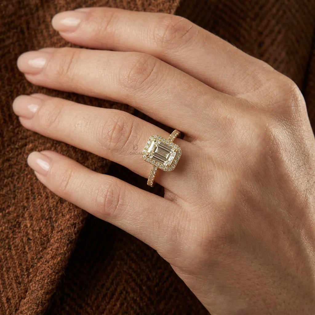 Yellow gold engagement ring with an emerald cut diamond center, a sparkling round diamond pave and halo setting a matching band, on a well-manicured hand