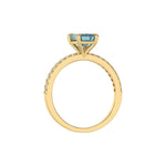 This yellow gold ring displayed in through finger view is made with a emerald solitaire diamond set in four-prong setting