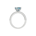 This white gold ring displayed in through finger view is made with a emerald solitaire diamond set in four-prong setting