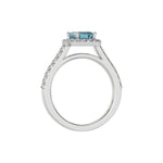 This white gold Emerald Diamond Halo Engagement Ring is made with a fancy blue emerald solitaire diamond set in a four-prong setting in through finger view