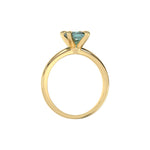 This yellow gold ring features a fancy Green cushion solitaire diamond elegantly secured in a four-prong setting on a solid gold band in through finger view