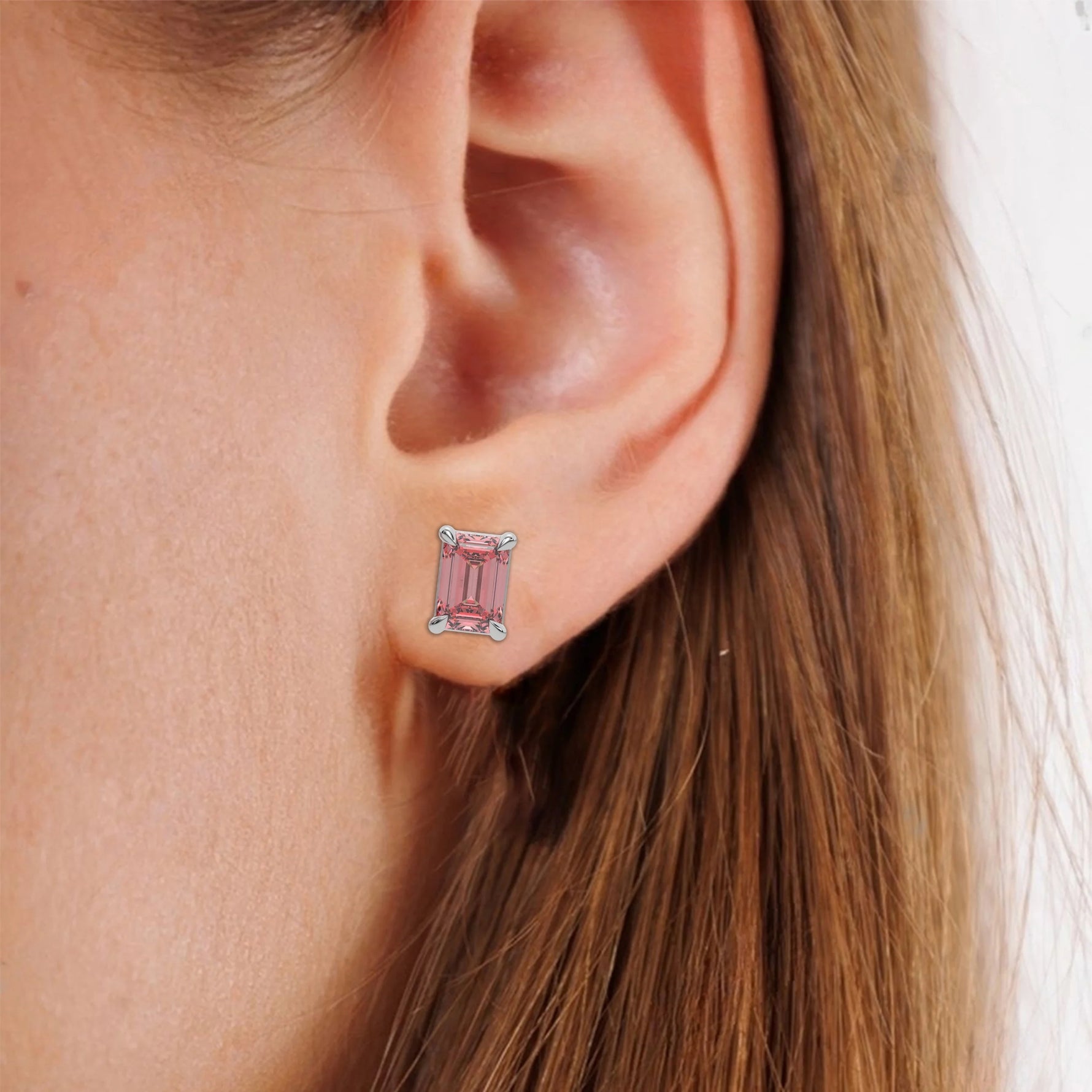 This white gold Classic Emerald Diamond Earrings made with an fancy pink emerald-cut diamonds set in a four prong setting