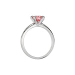 This white gold ring features a fancy Pink round solitaire diamond elegantly secured in a four-prong setting on a solid gold band in through finger view