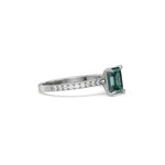 This white gold ring displayed in side view is made with a emerald solitaire diamond set in four-prong setting