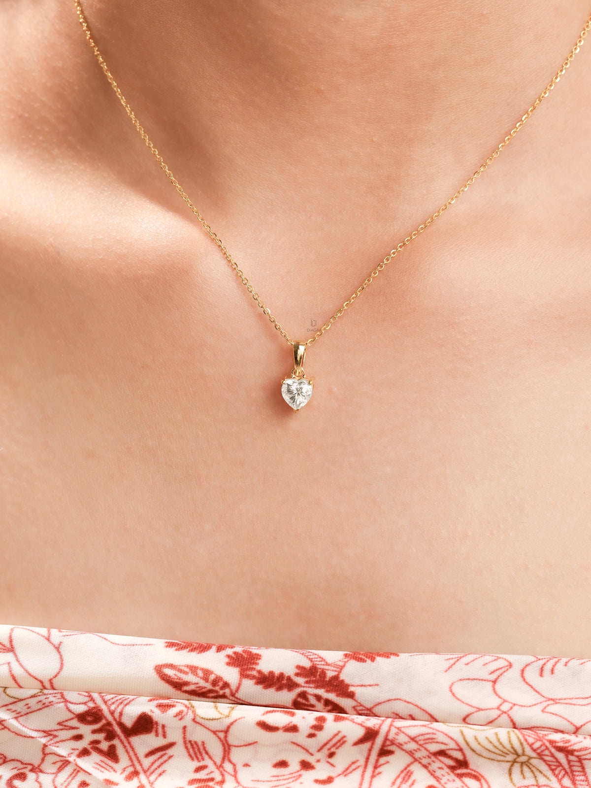 Woman wearing a delicate yellow gold heart diamond necklace featuring a prong-set heart solitaire pendant.