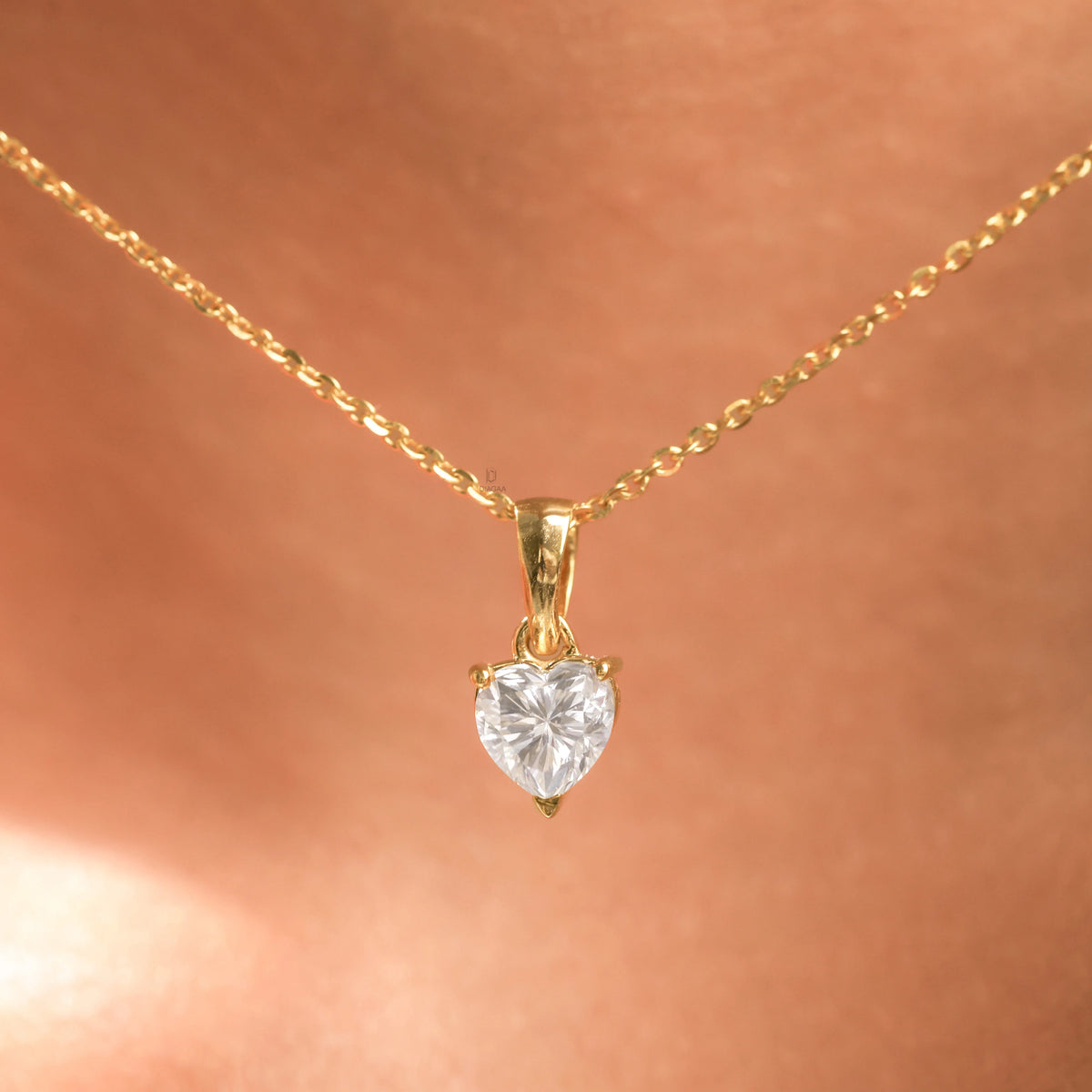 Woman wearing a delicate 14K yellow gold heart diamond necklace featuring a prong-set heart solitaire pendant.