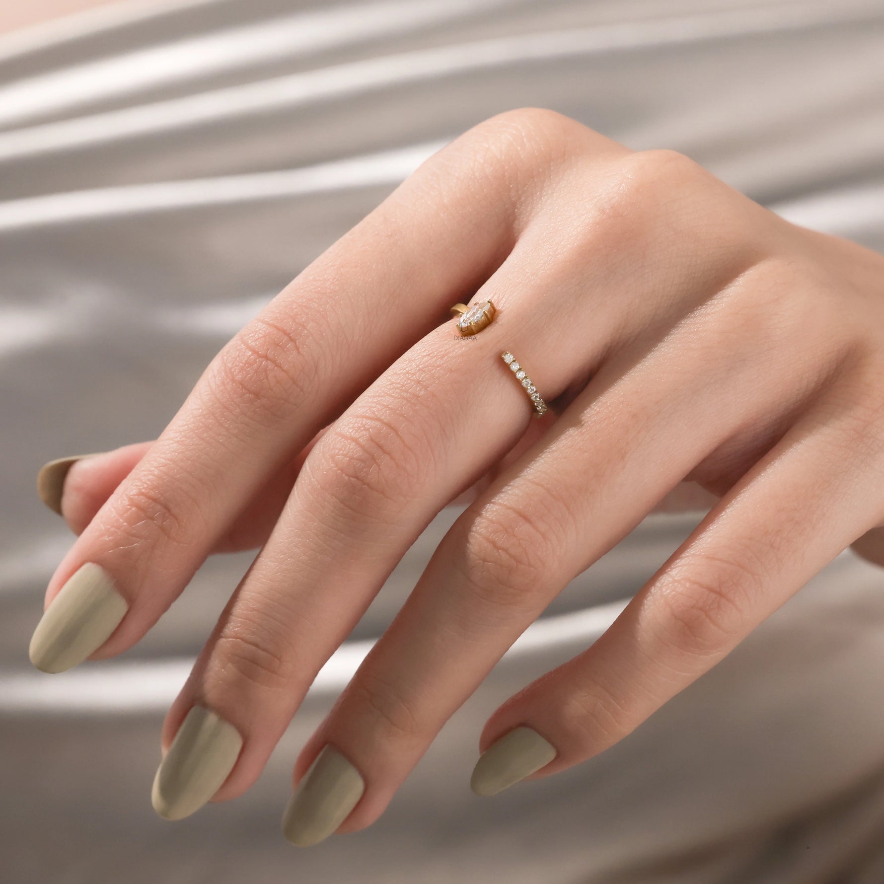 14k Yellow gold open cuff ring with a marquise cut diamond and small round diamond pave set band worn on a woman's index finger.