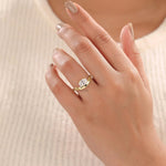 yellow gold oval diamond hidden halo solitaire engagement ring with a curved band on a woman's hand