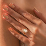 hand wearing a this elegant 14k yellow gold ring unique oval center stone ring,designed as a round diamond halo set solitaire oval diamond engagement ring 