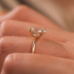 18K yellow gold oval diamond hidden halo engagement ring on a woman's hand