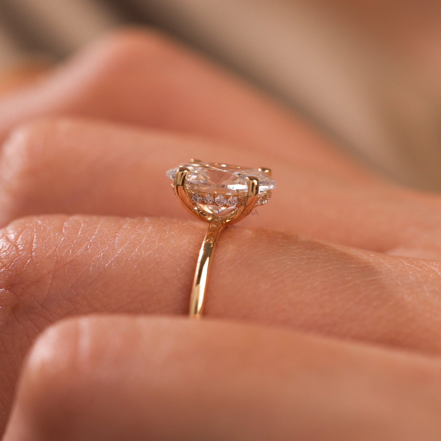 18K yellow gold oval diamond hidden halo engagement ring on a woman's hand