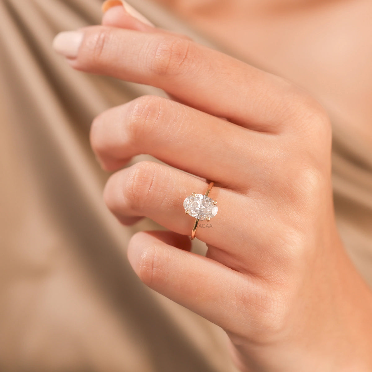 10K yellow gold oval diamond hidden halo engagement ring on a woman's hand