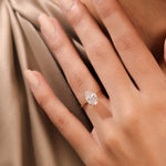 Classic yellow gold solitaire engagement ring featuring a brilliant oval center diamond, modeled in a hand.