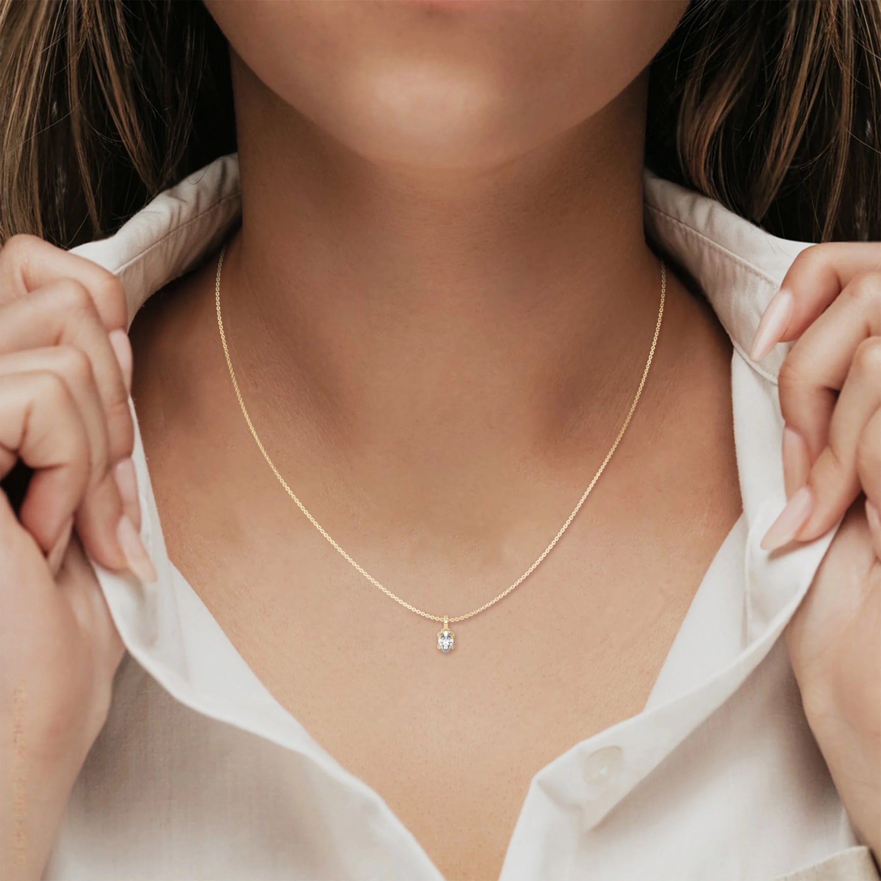 This yellow gold solitaire necklace featuring an oval diamond securely set in four prongs