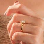 Pear cut diamond engagement ring with a yellow gold bezel setting hidden halo ring worn on a woman's hand.