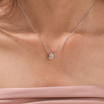 Model wearing a classic 18K white gold Pear Diamond necklace featuring a teardrop bezel-set solitaire pendant.