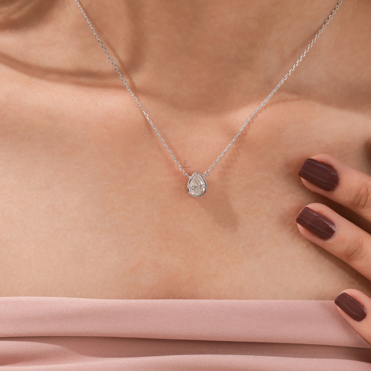 Model wearing a classic white gold Pear Diamond necklace featuring a teardrop bezel-set solitaire pendant.