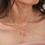 Model wearing a classic white gold Pear Diamond necklace featuring a teardrop bezel-set solitaire pendant.