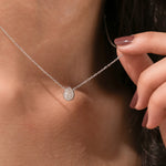 Model wearing a classic white gold Pear Diamond necklace featuring a teardrop bezel-set solitaire pendant.