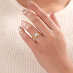 Woman wearing a 18K yellow gold Curve ring with Pear and round diamonds hidden vhalo ring