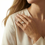 Woman wearing a pear shaped Solitaire diamond engagement ring with a yellow gold round side stone pave band, hand resting on her shoulder.