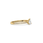 This yellow gold ring displayed in side view is made with a Pear solitaire diamond set in four-prong setting