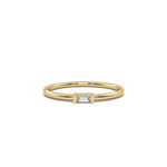 This yellow gold A thin gold band showcases a baguette diamond held in a bar prong setting in top view